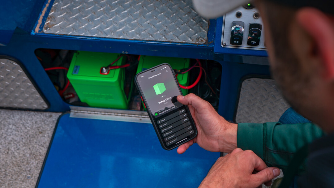 Angler Kneeling down to check his Batteries using the bluetooth Guardian App – 1920X1080 Angler Kneeling down to check his Batteries using the bluetooth Guardian App 1920X1080