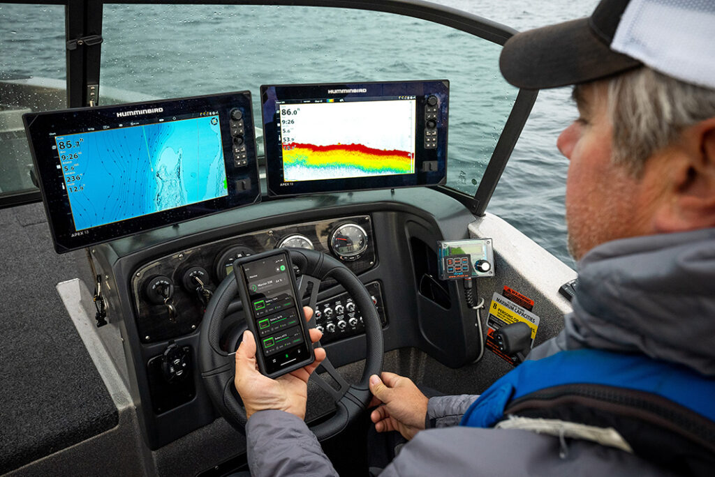 Angler Checking Norsk Guardian App while in boat fishing electronics lithium battery