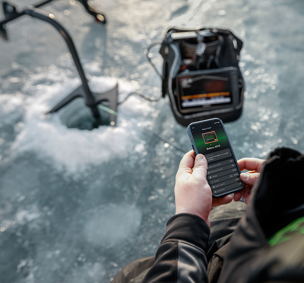 Ice Fishing Angler Checking Bluetooth Norsk Guardian App While Fishing With Live Imaging Forward Facing Sonar FFS LiveScope