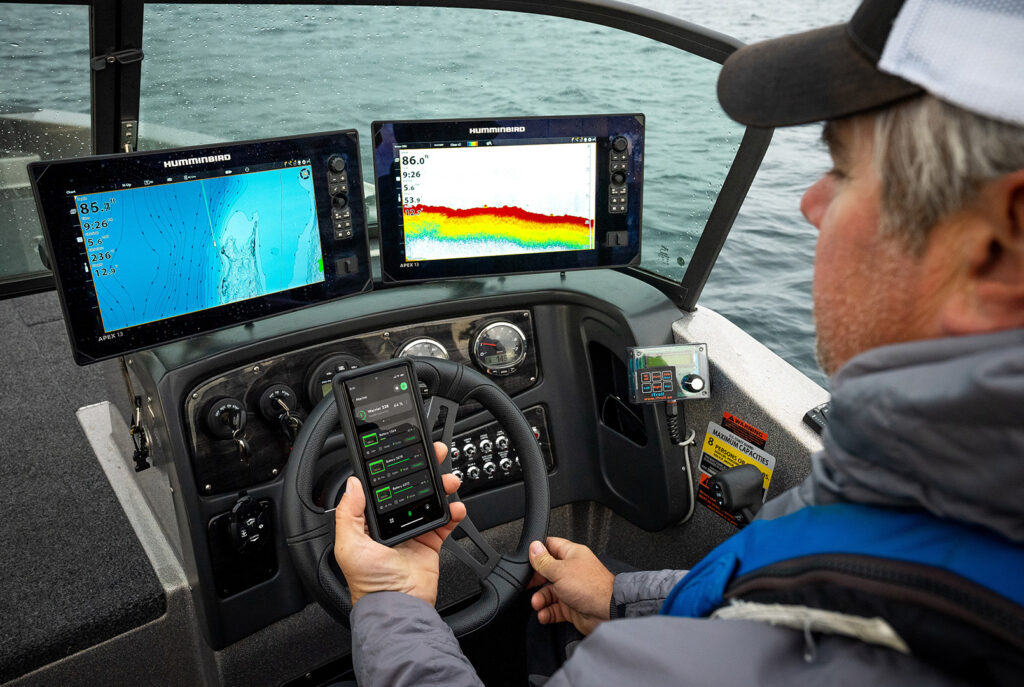 Angler Checking Norsk Lithium Guardian App In Boat James Holst